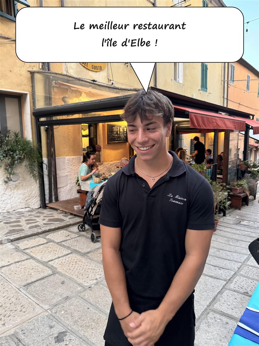 Tommaso, de l'équipe de La Miniera del Gusto, devant l'enseigne du restaurant